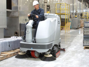 Cleaning industrial floor with a heavy equipment.